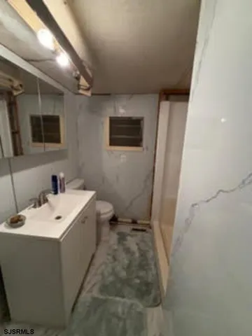 a bathroom with a sink mirror and toilet