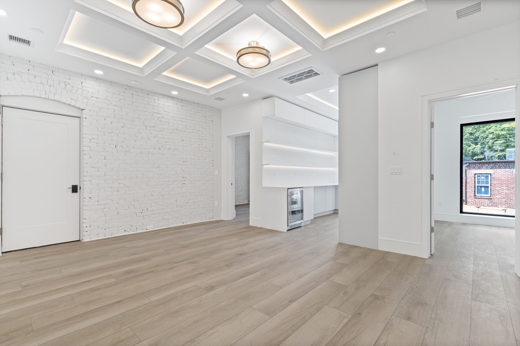 1578 Beacon Street, Unit 202 Brookline, MA 02446 - Photo 4 of 18 a view of an empty room with a window and wooden floor