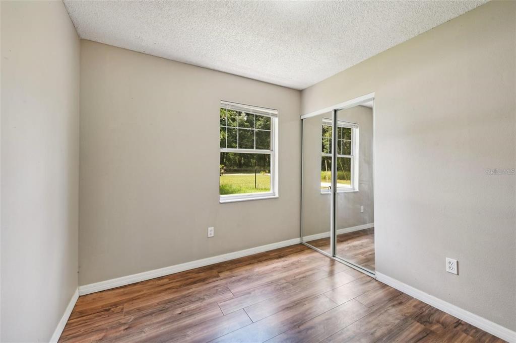 5 Cedar Lane Ocala, FL 34472 - Photo 18 of 24 an empty room with wooden floor and windows