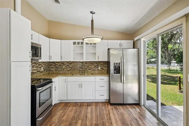 a kitchen with stainless steel appliances a refrigerator sink and microwave