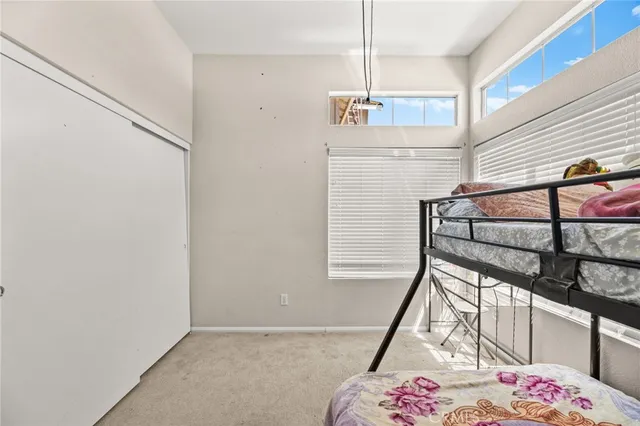 a view of a bedroom with a bed and wooden floor