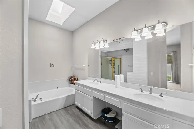 a bathroom with a tub a double vanity sink and a mirror