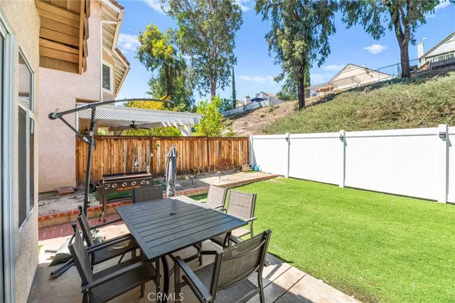 a view of a backyard with table and chairs with wooden fence