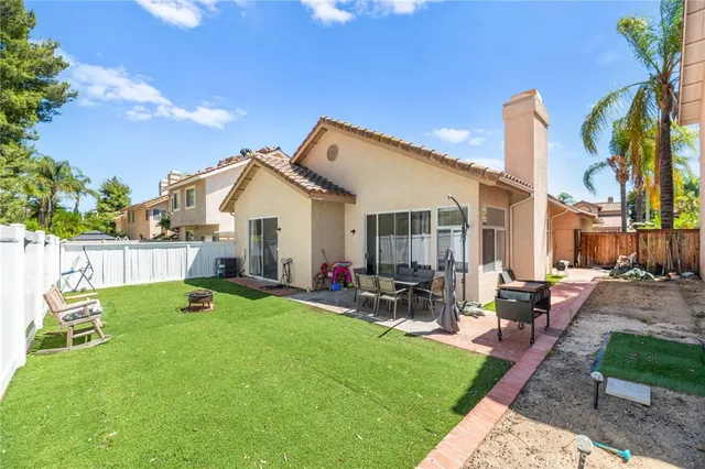 a view of a house with backyard sitting area and garden