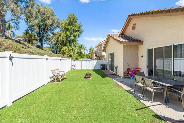 a view of a backyard with a small cabin and wooden fence