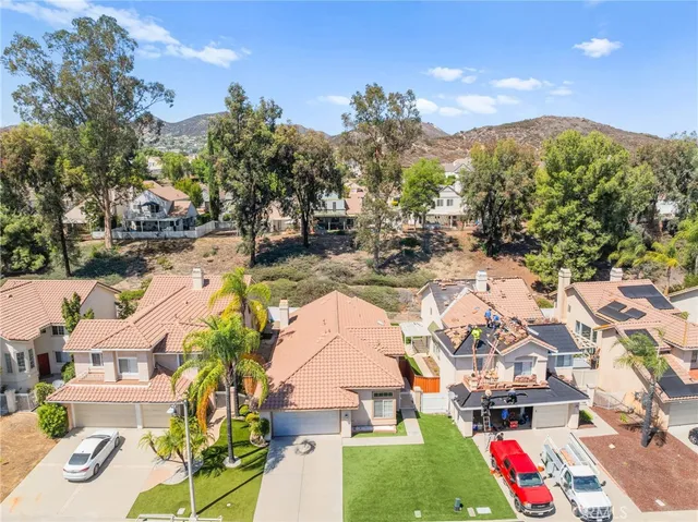 an aerial view of residential houses with outdoor space and trees