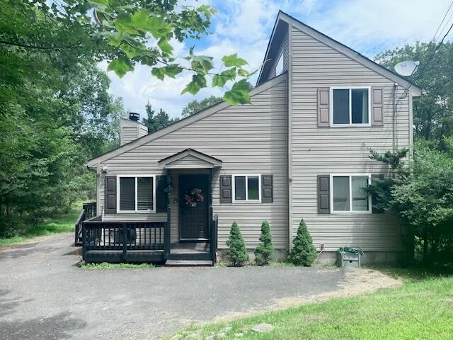 a view of a house with a yard and sitting area