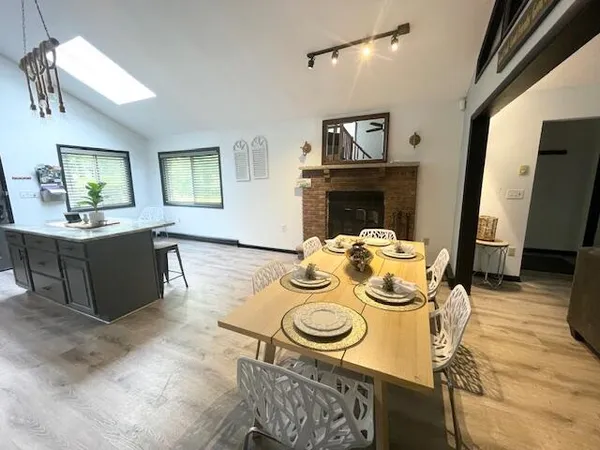 a view of a dining room with furniture a chandelier and wooden floor