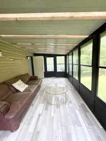 a view of a room with wooden floor and large window