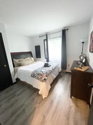 a bedroom with a bed and wooden floor