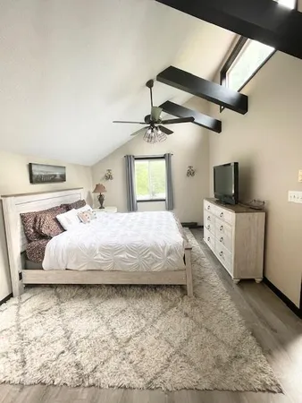 a bedroom with a bed and a flat screen tv