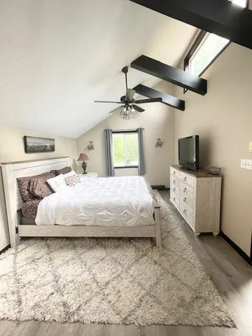 a bedroom with a bed and a flat screen tv