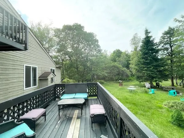 a view of a deck with chairs and a yard with wooden fence