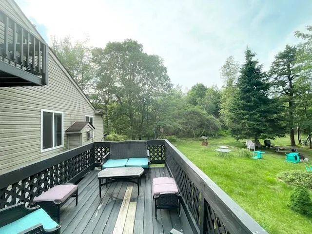 a view of a deck with chairs and a yard with wooden fence