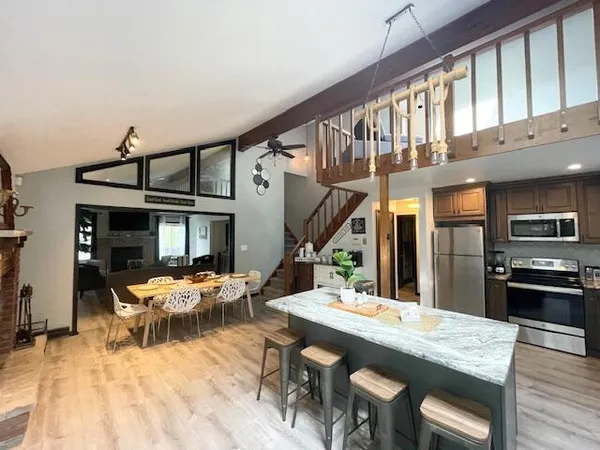 a view of a dining room with furniture and a kitchen