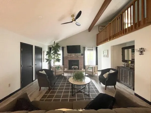 a living room with furniture a fireplace and a flat screen tv