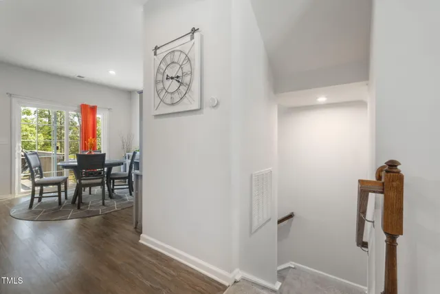 a view of a hallway with chairs and wooden floor