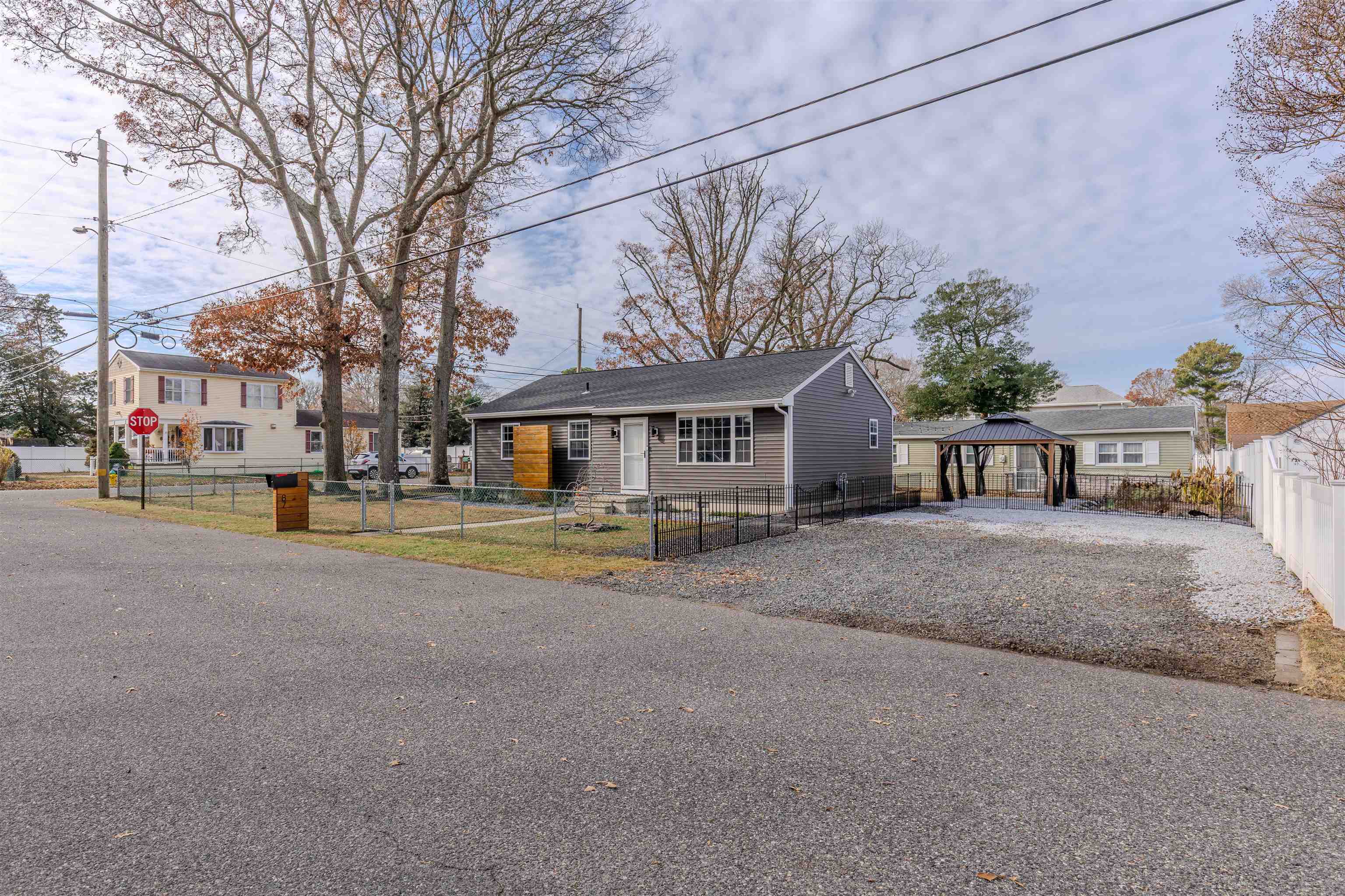 87 Rose Villas, NJ 08251 - Photo 18 of 27 a front view of a house with a garden and trees