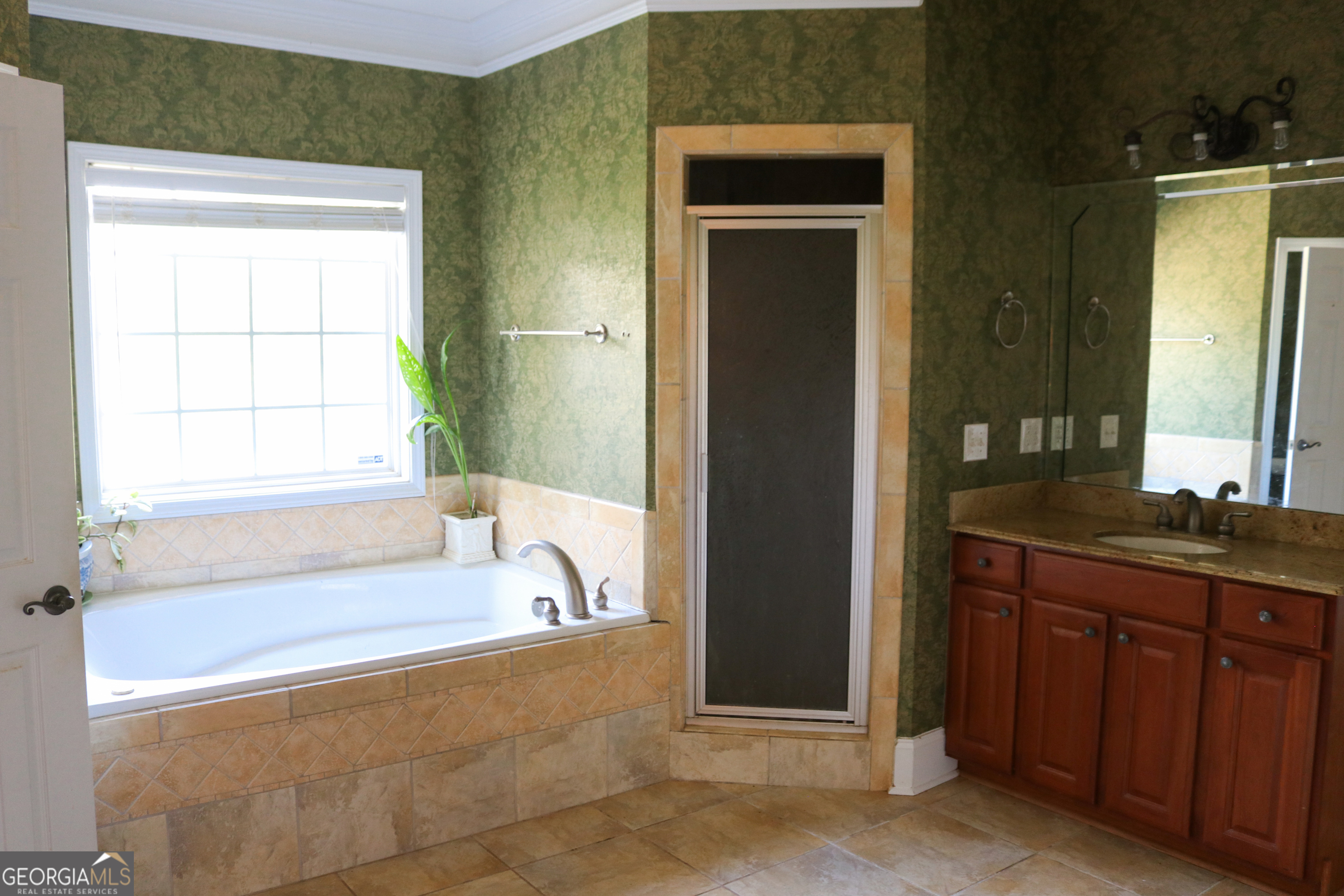 1224 Walker Road Madison, GA 30650 - Photo 22 of 57 a bathroom with a granite countertop sink and a bathtub
