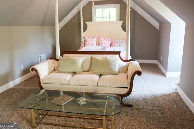 a white couch sitting in a living room next to a window