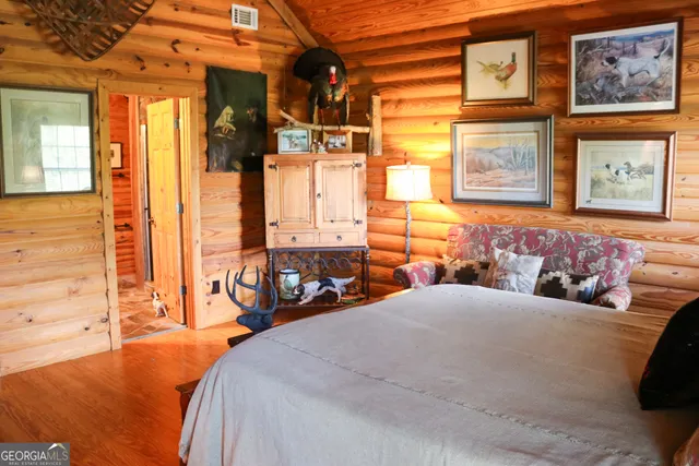 a bedroom with a bed a window and painting on the wall