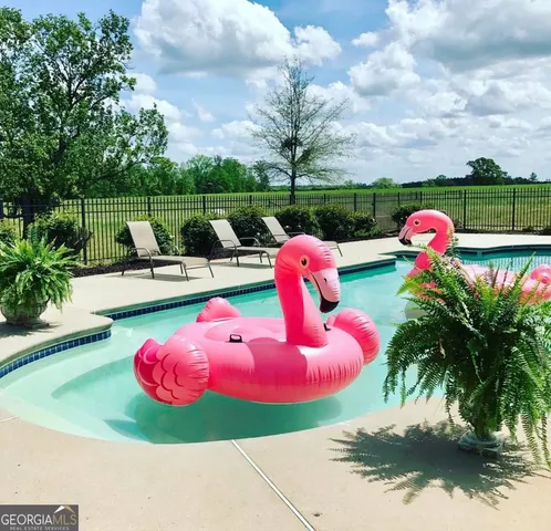 a view of a backyard with table and chairs plants and a fire pit