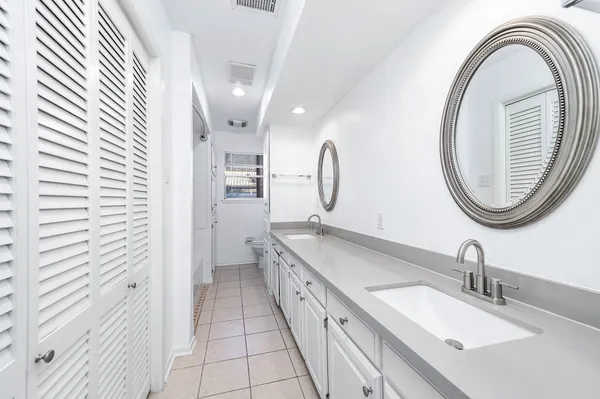 a bathroom with a double vanity sink and a mirror