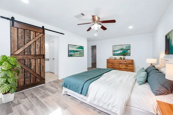 a bedroom with a large bed and a chandelier