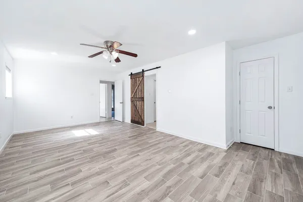 a view of a room with wooden floor and ceiling fan