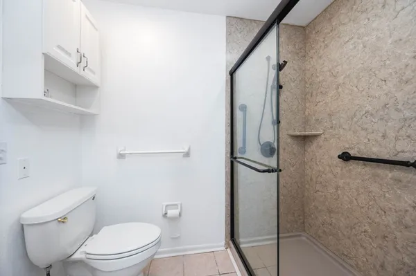 a bathroom with a granite countertop toilet and a shower