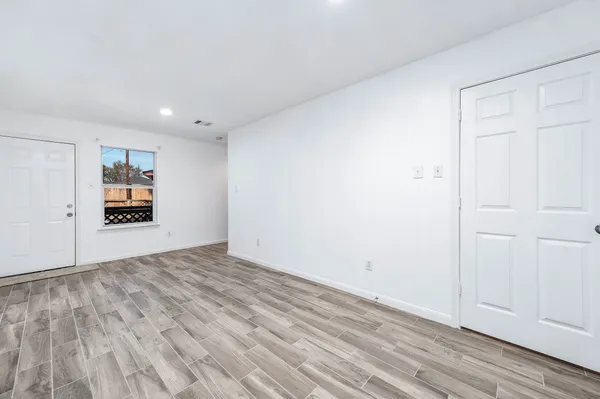 a view of empty room with wooden floor