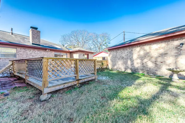 a view of a small yard with wooden fence and a bench
