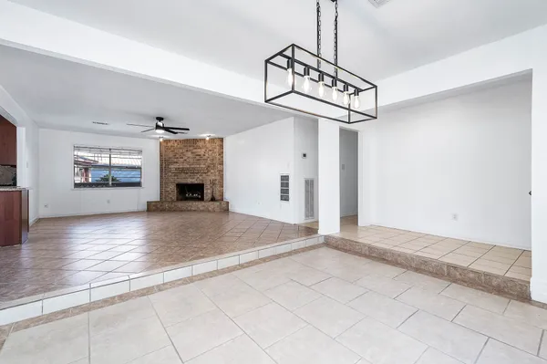 a view of a livingroom with a fireplace a chandelier and wooden floor