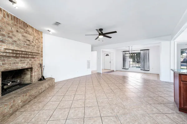 a view of an empty room with a fireplace and a window