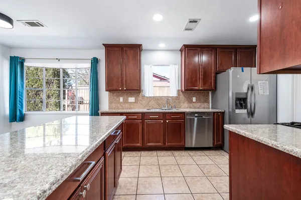 a kitchen with stainless steel appliances granite countertop a sink stove and refrigerator