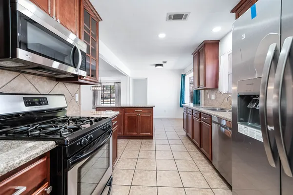 a kitchen with stainless steel appliances granite countertop a stove a sink and a refrigerator