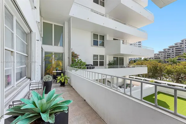 a view of a balcony with chairs potted plants