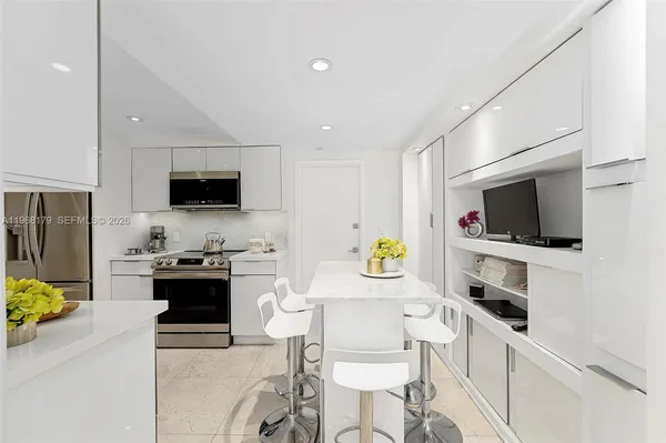 a view of kitchen with microwave stove refrigerator dining table and chairs