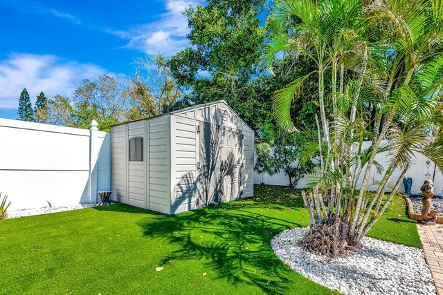 a view of backyard with potted plants and large tree