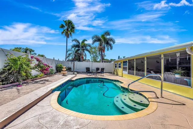 a view of a swimming pool with a lounge chair and a fire pit