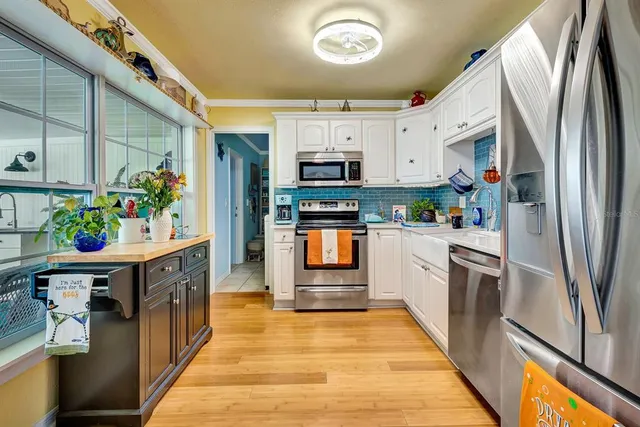 a kitchen with stainless steel appliances granite countertop a refrigerator a stove top oven a sink and dishwasher