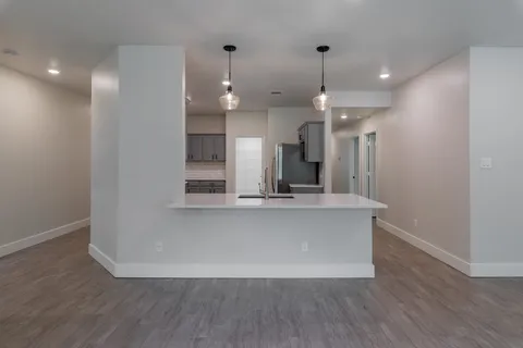 a view of a kitchen with wooden floor and a large window