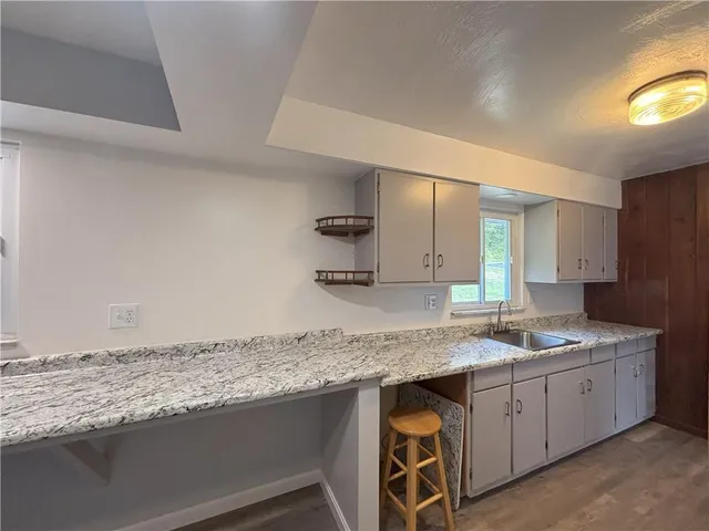 a kitchen with granite countertop a sink and a stove