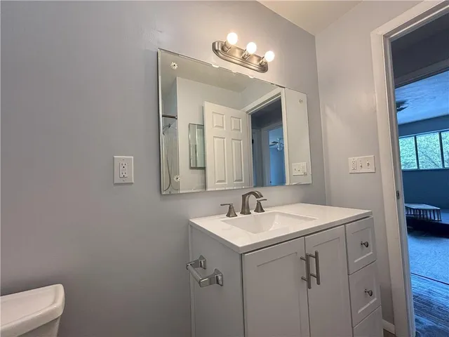 a bathroom with a sink a toilet and a mirror