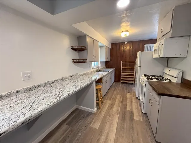 a kitchen with stainless steel appliances granite countertop a stove a sink and a refrigerator