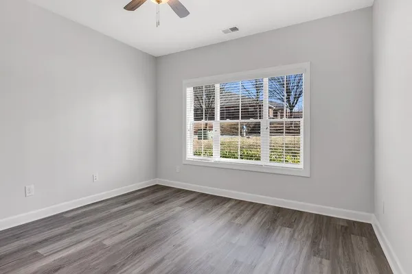 an empty room with a window and wooden floor