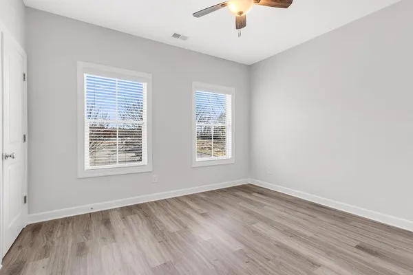 an empty room with a window and wooden floor