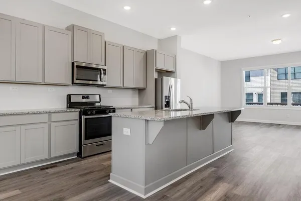 a kitchen with stainless steel appliances a sink cabinets and wooden floor