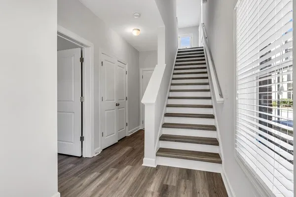 a view of a hallway with wooden floor and white walls