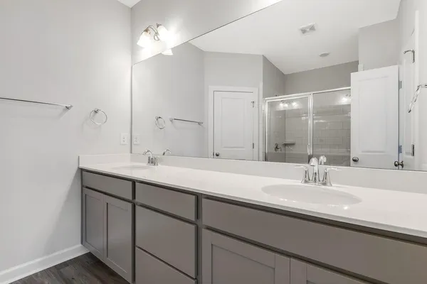 a bathroom with double sink and a mirror